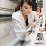 Eine Frau im Laborkittel bedient ein Laborgerät